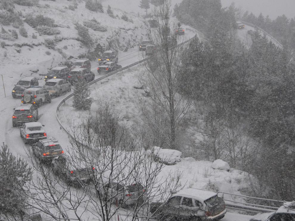 Colas de vehículos en la carretera que sube a la estación de Cerler en invierno.