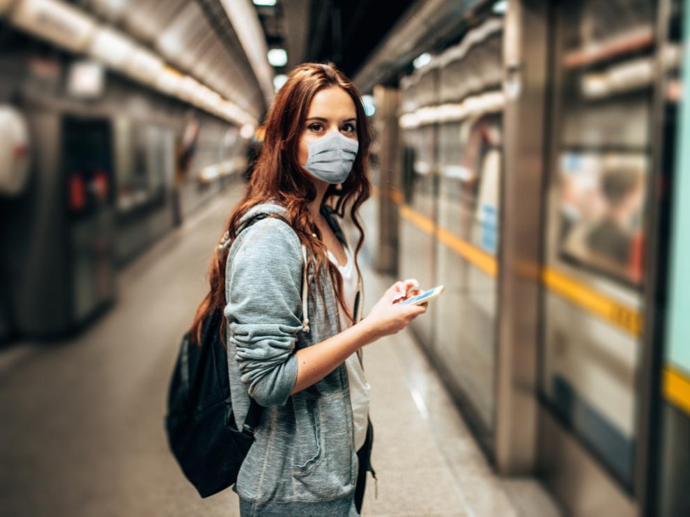 Mujer con mascarilla en la estación