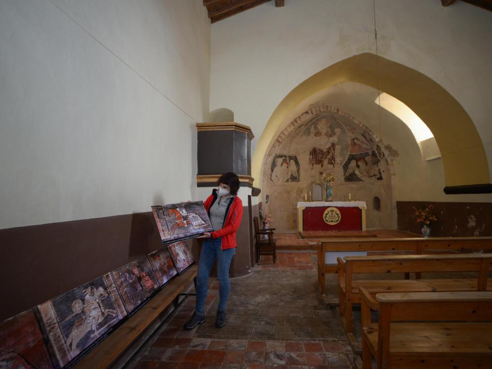 Sara Ros, en el interior de la ermita de Camañas, muestra reproducciones de la decoración de la techumbre.