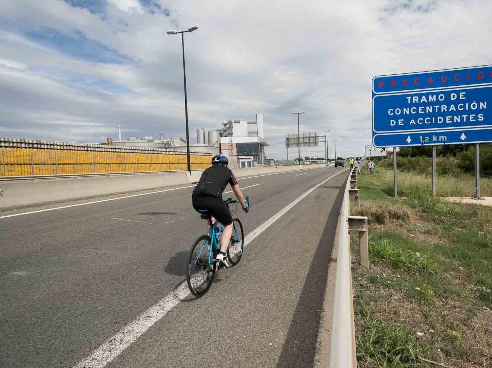 Un ciclista circula junto al lugar donde se produjo el atropello del menor de 15 años en la A-68, a la altura de La Cartuja.