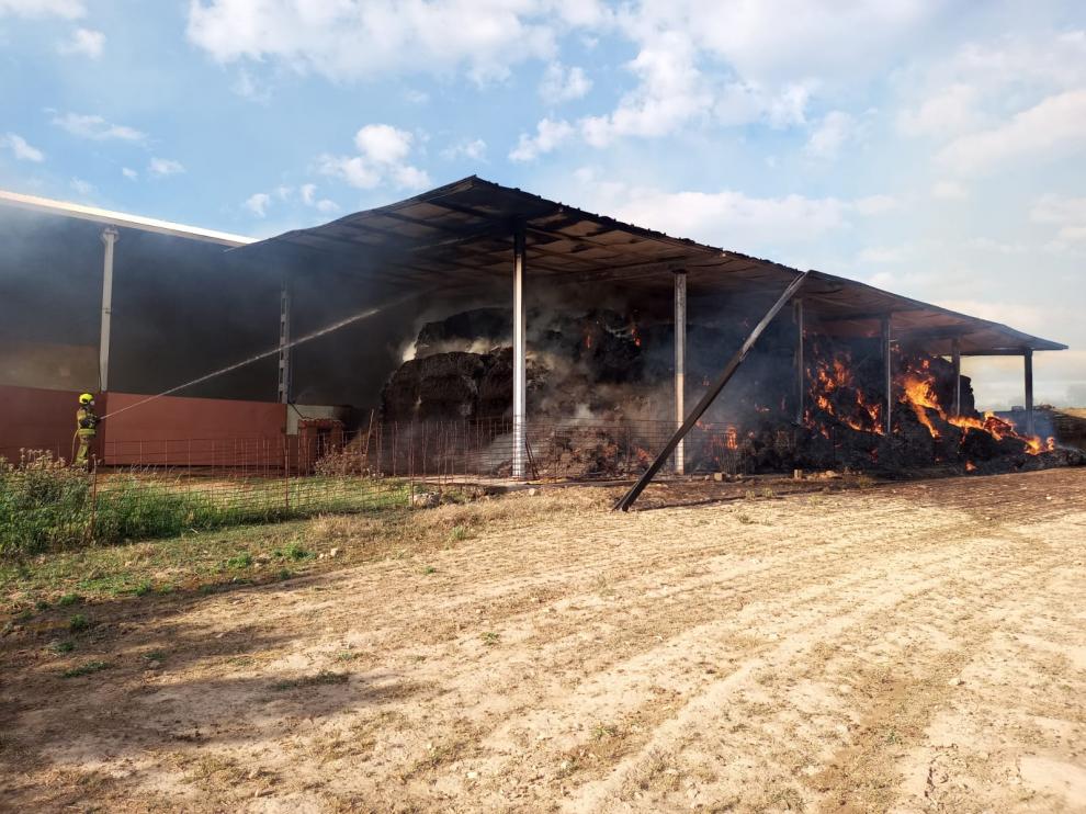 Los bomberos del parque de Barbastro han acudido a sofocar el incendio de la nave de paja de Bierge.