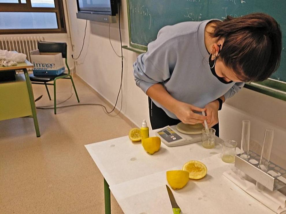 Una alumna del IES Valle del Ebro realiza experimentos para comprobar si el jugo del cítrico pierde sus vitaminas una vez exprimido