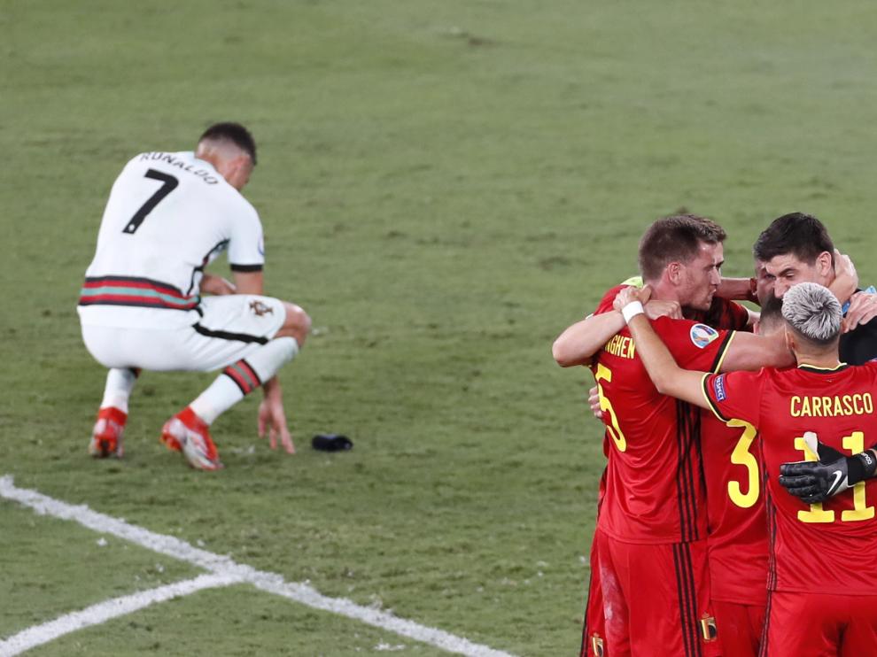 Cristiano Ronaldo se lamenta en el suelo mientras los jugadores de Bélgica celebran el triunfo