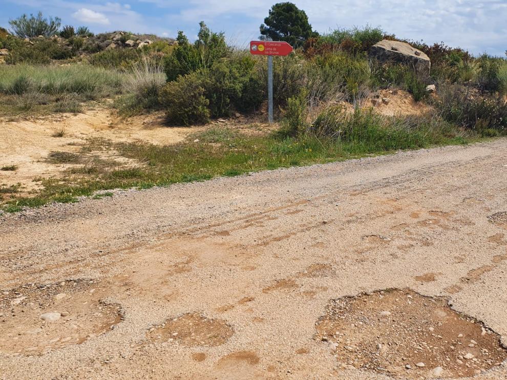 Una señal informa de la proximidad del yacimiento arqueológico de El Cascarujo en la pista que conduce al embalse de Civán desde Alcañiz.
