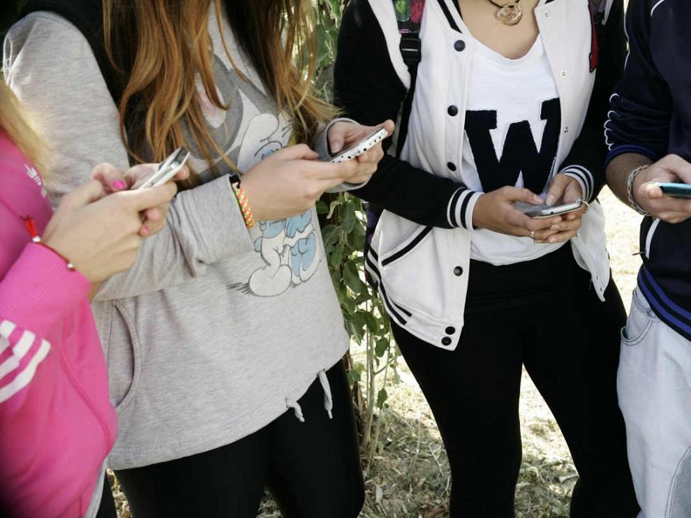 Un grupo de adolescentes reunidos con sus móviles.