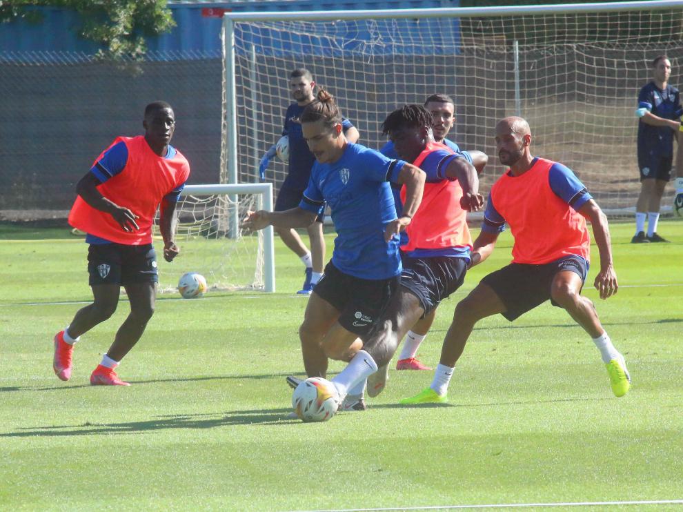 Ronald y Mikel Rico defienden a Seoane durante el entrenamiento de la SD Huesca de este viernes.