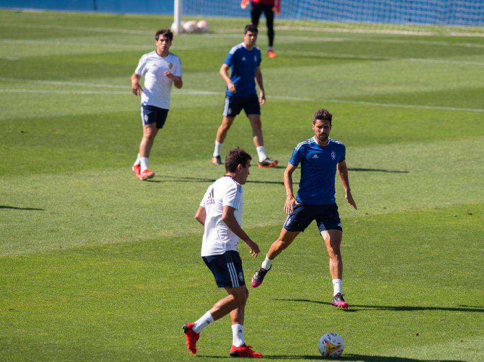 Zapater lleva la pelota ante Adrián González, ante la mirada de Iván Azón y en el partido de entrenamiento jugado por el Real Zaragoza en la mañana de este miércoles en La Romareda.