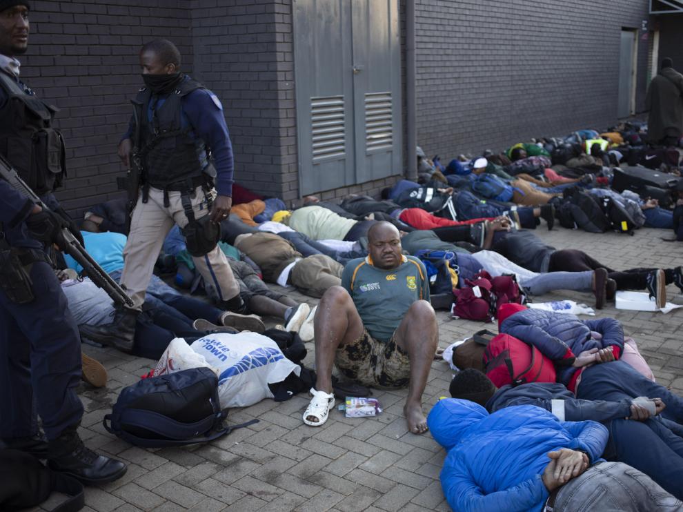 Decenas de personas tendidas en el suelo bajo arresto en Sudáfrica