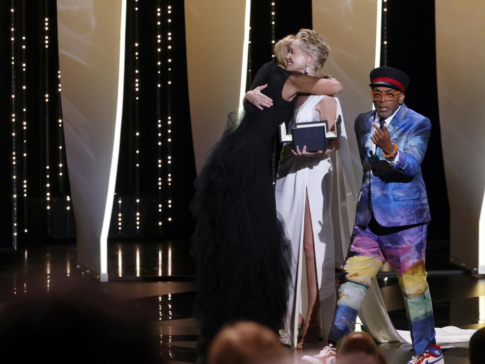 La directora Julia Ducournau abraza a Sharon Stone en presencia de Spike Lee.