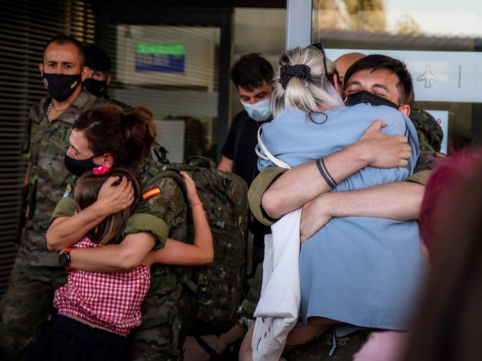 Dos militares de la Brigada Aragón saludan a sus familiares en el aeropuerto de Zaragoza.