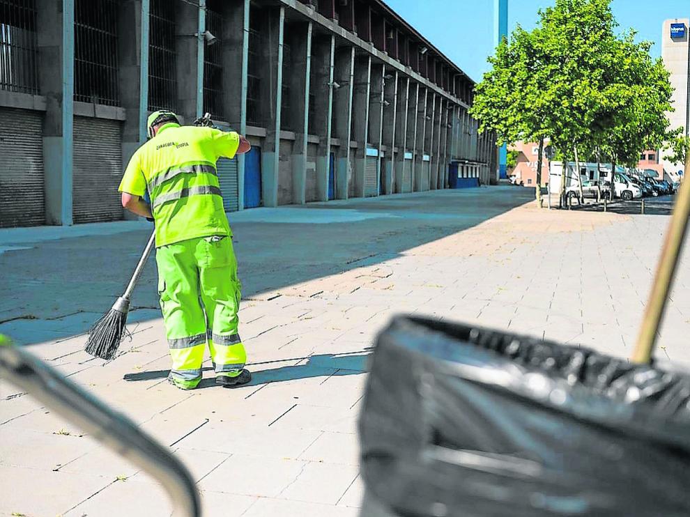 Un operario de limpieza barre el suelo junto al estadio de La Romareda, ayer.