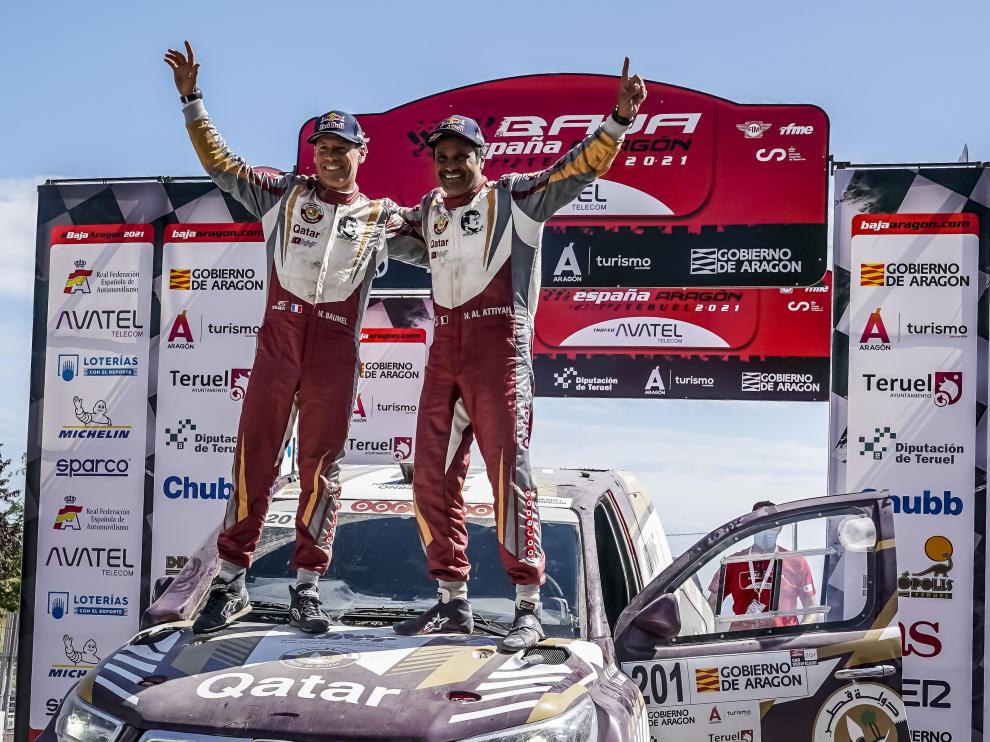 Al-Attiyah celebra el triunfo en la Baja Aragón subido en su coche con su copiloto, Baumel.