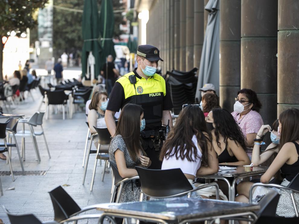 Un policía obliga del uso obligatorio de la mascarilla en Zaragoza, en una imagen de archivo.