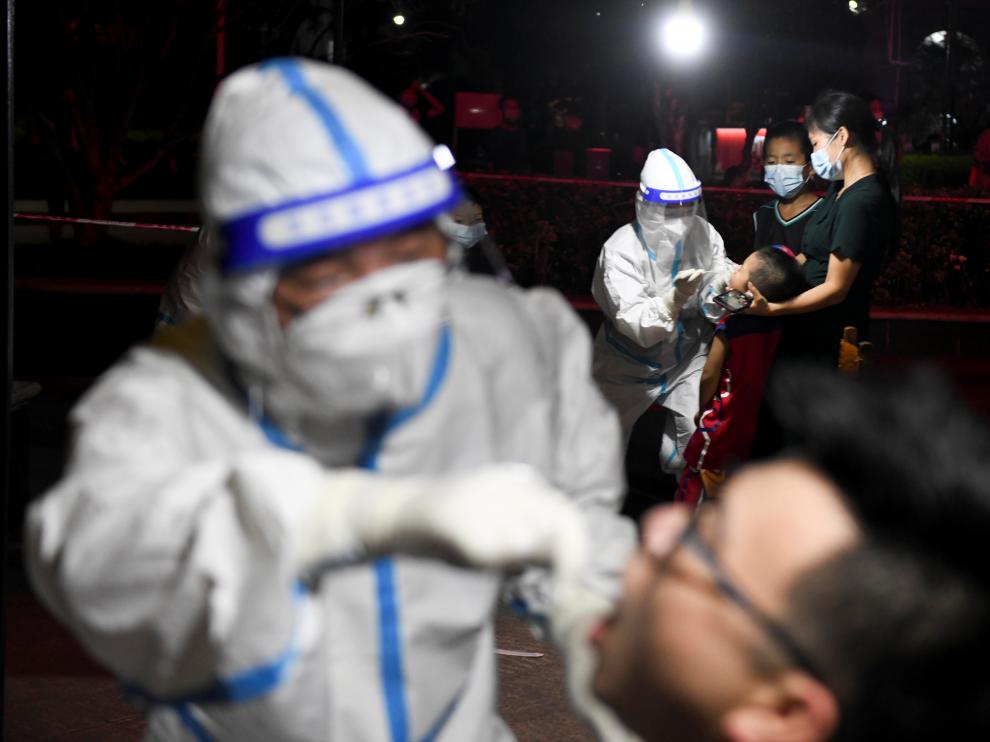 Medical workers collect swab from residents following the COVID-19 outbreak in Zhangjiajie