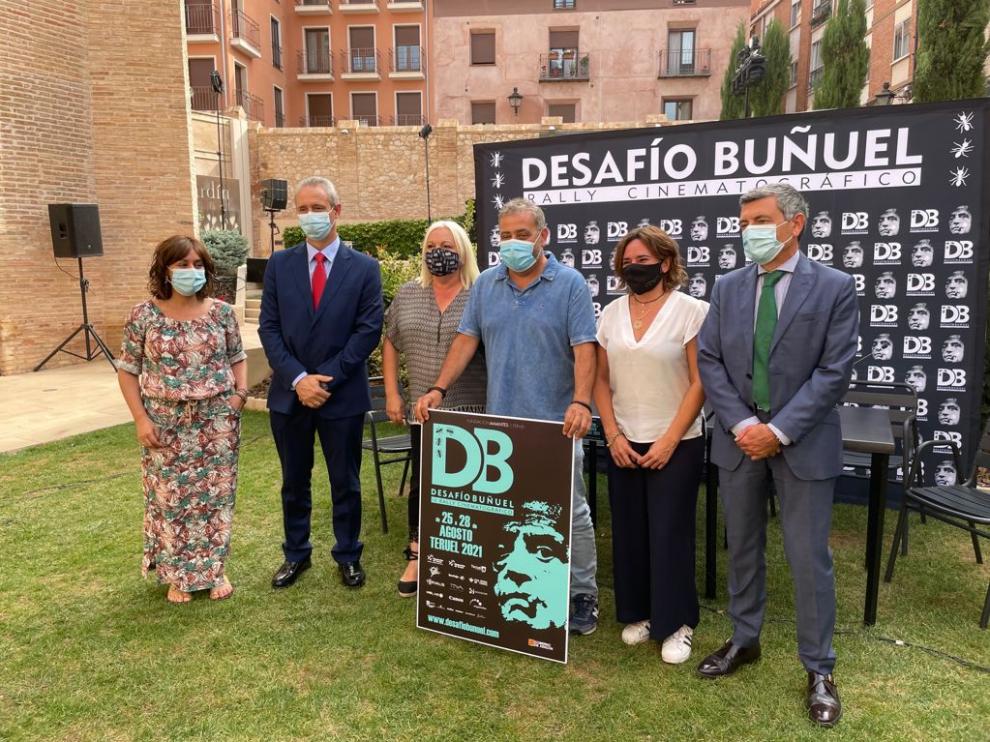 Pimpi López, director del Rally, sostiene el cartel del Desafío Buñuel junto al resto de patrocinadores.