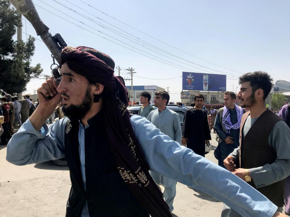FILE PHOTO: A member of Taliban forces inspects the area outside Hamid Karzai International Airport in Kabul