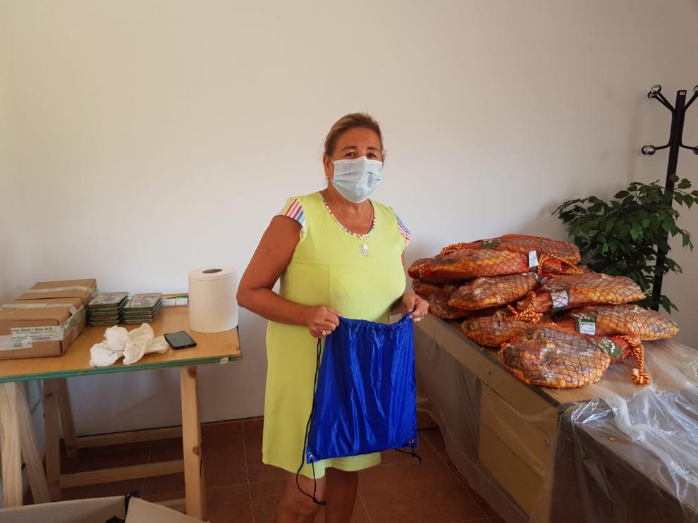 Pilar Molina, alcaldesa de Allueva, junto a los jamones que se han regalado a sus vecinos.