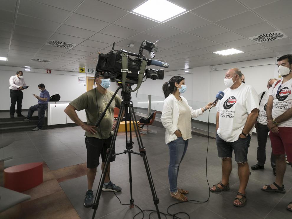 Los representantes del comité del bus atienden a la prensa momentos antes de empezar la reunión en el SAMA