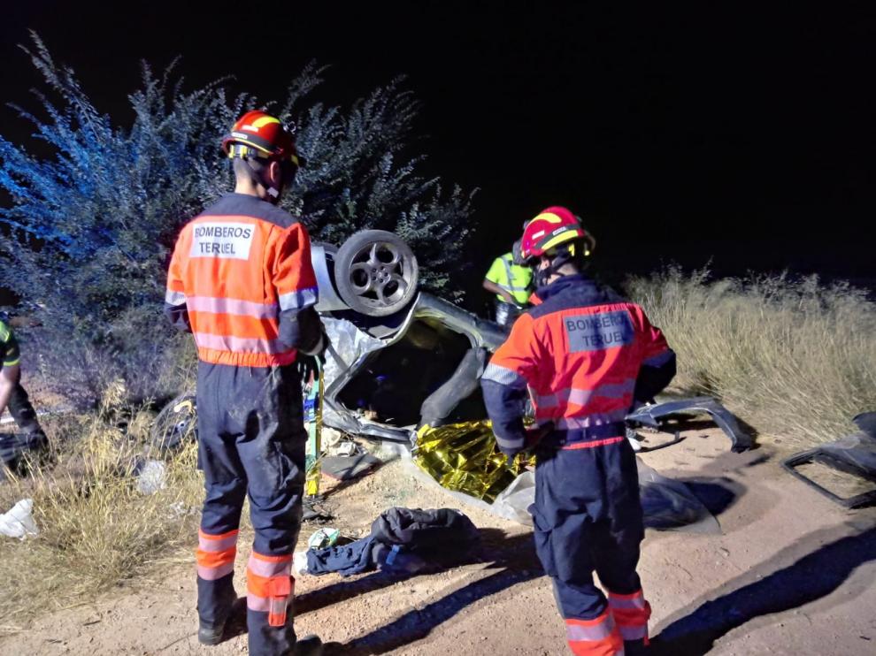 Los Bomberos de Teruel, junto al vehículo volcado.