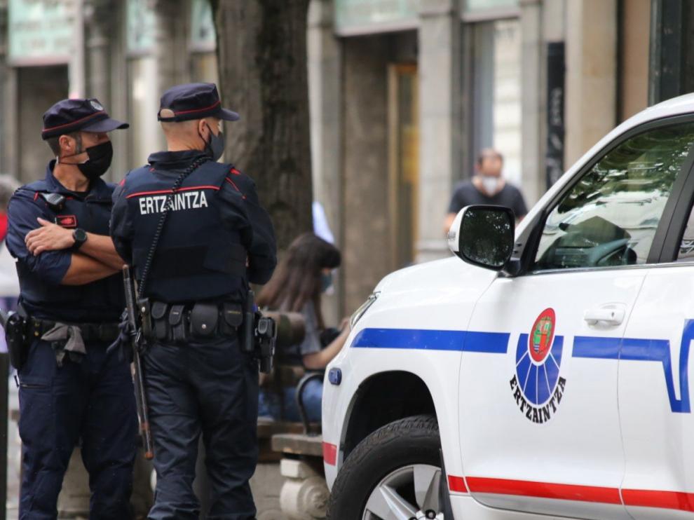 Dos policías vascos junto a un coche patrulla en San Sebastián.