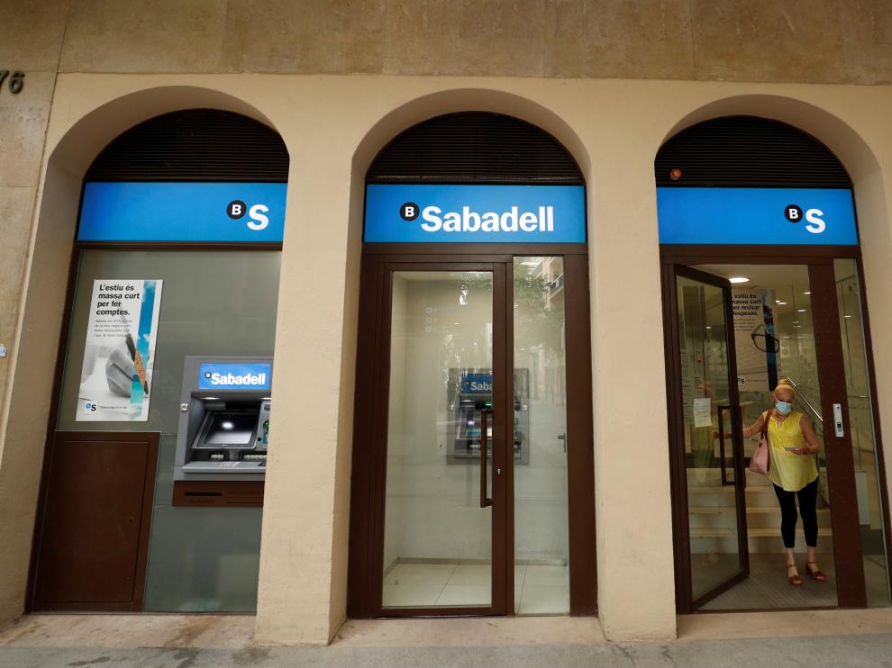 A woman leaves a Sabadell bank office in Barcelona