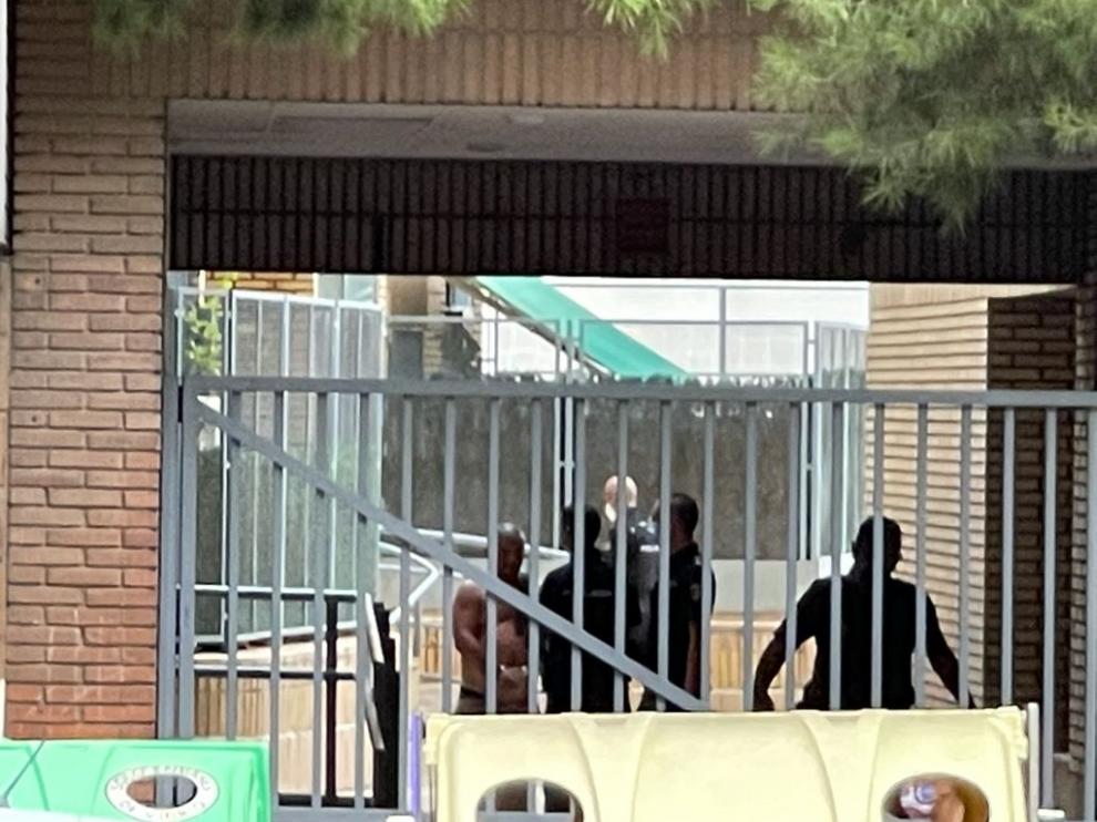 A la izquierda, el detenido por acuchillar a su compañero de piso es conducido por la Policía.