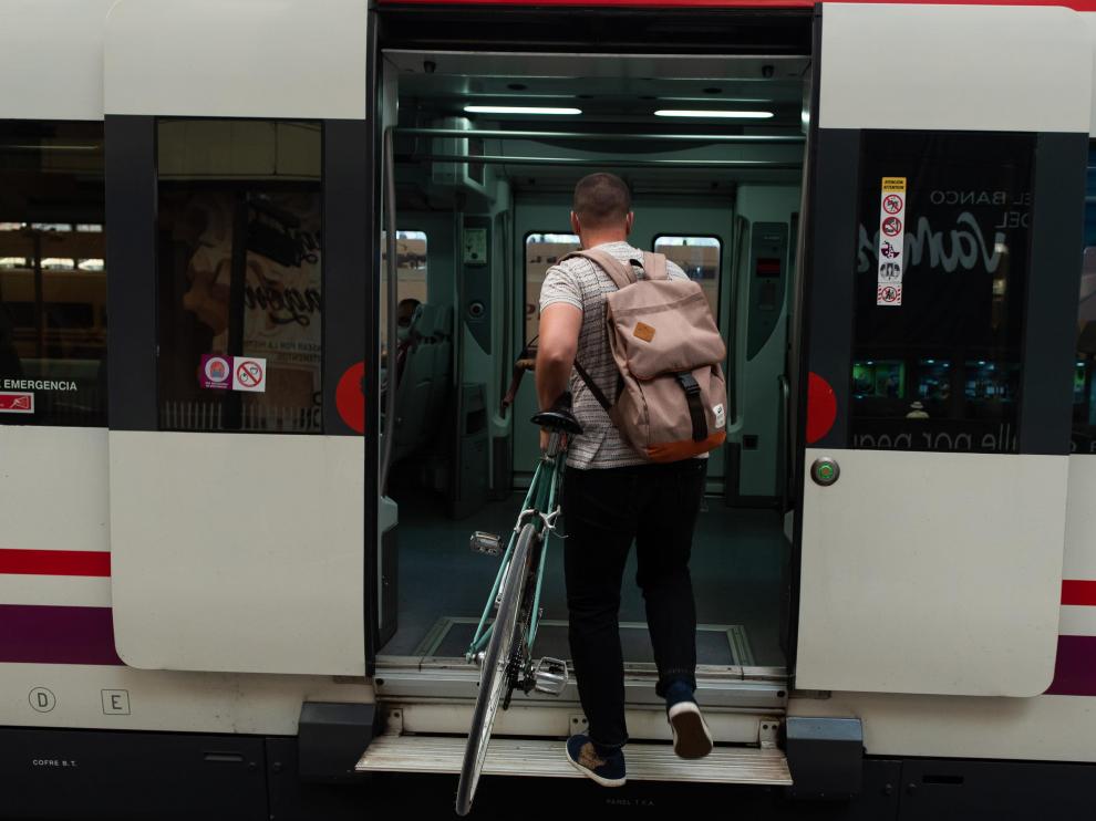 Un ciclista accede a un tren de la línea de Cercanías Casetas-Miraflores.