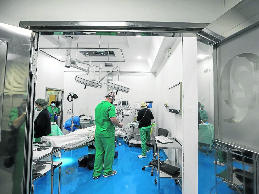 Varios profesionales preparan un quirófano de la Clínica del Pilar para una intervención.