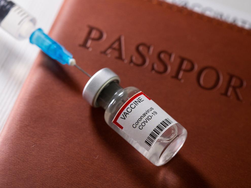 FILE PHOTO: A syringe and a vial labelled "coronavirus disease (COVID-19) vaccine" are placed on a passport in this illustration picture