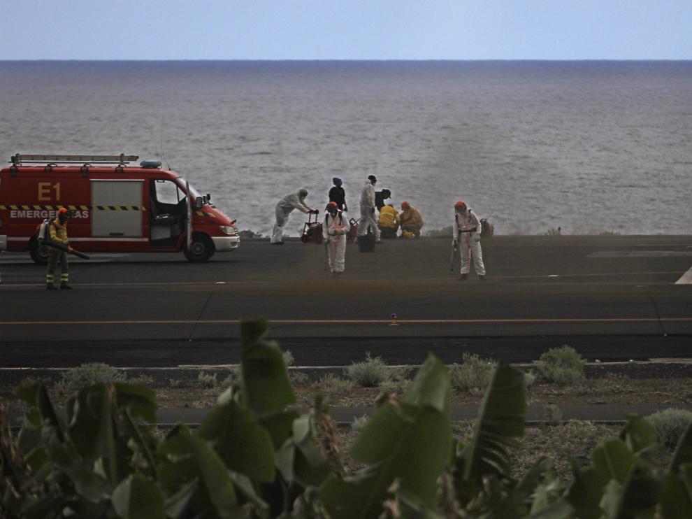 Operarios limpian de cenizas una pista del aeropuerto de La Palma,
