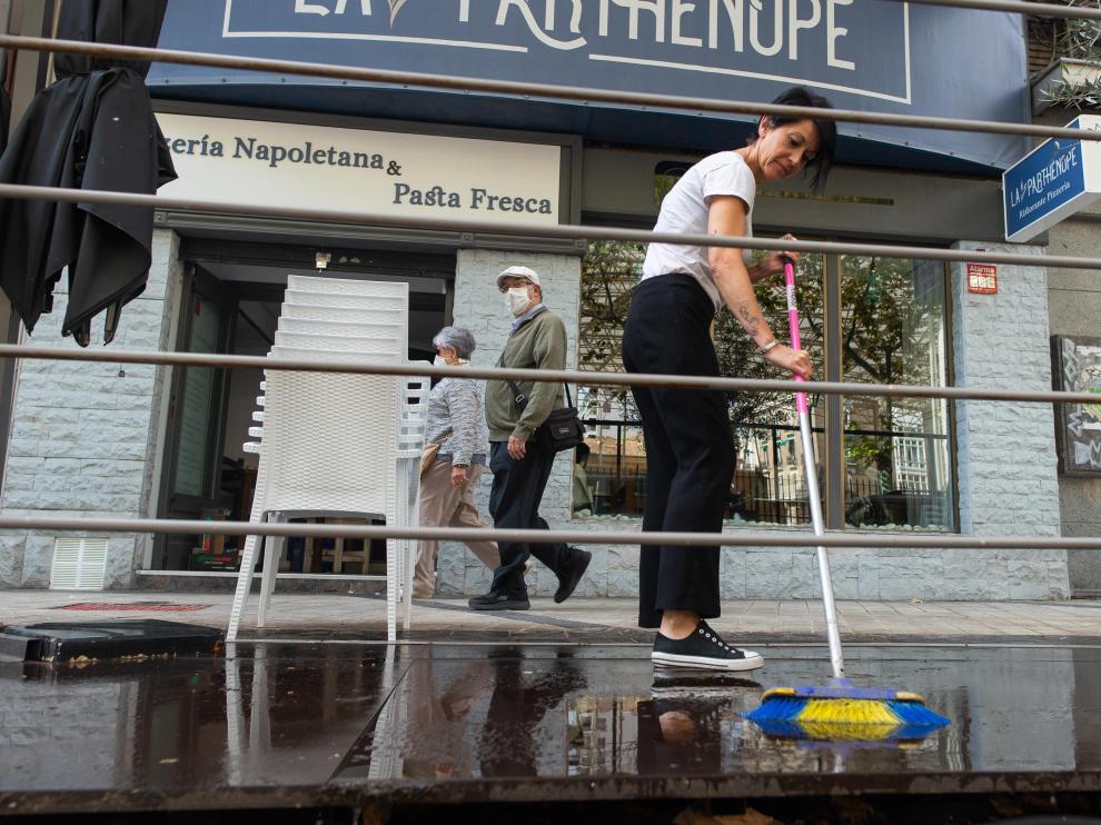Una trabajadora se prepara para abrir la terraza de un céntrico restaurante,
