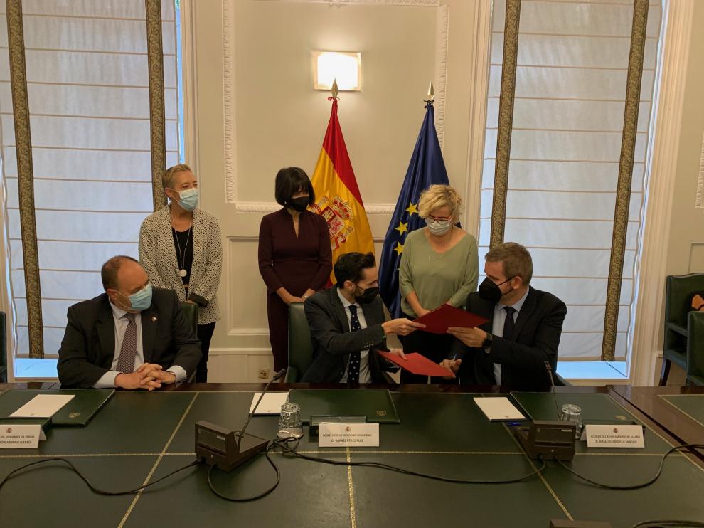 De izquierda a derecha, el subdelegado del Gobierno en Teruel, José Ramón Morro; el secretario de Estado de Seguridad, Rafael Pérez; y el alcalde de Alcañiz, Ignacio Urquizu, firman la incorporación del municipio al sistema VioGén.