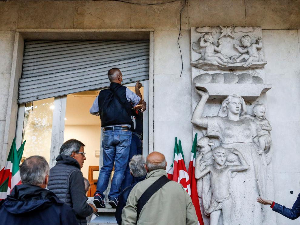 Varias personas arreglando los desperfectos de la sede del sindicato CGIL ITALY CLASHES AFTERMATH