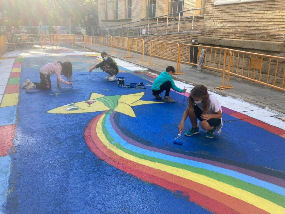 Miembros del Consejo de la Ciudad de las Niñas y los Niños de Huesca, pintando una calle peatonal.