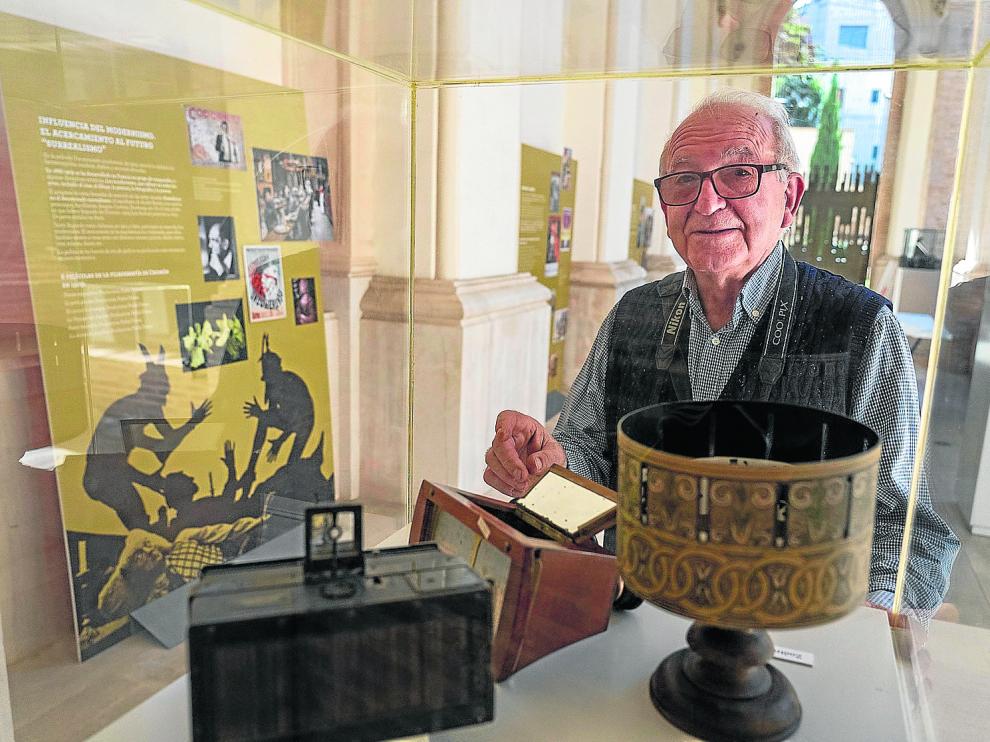 Julio Sánchez Millán, comisario de la muestra, junto a un zoótropo y otros aparatos de cine.