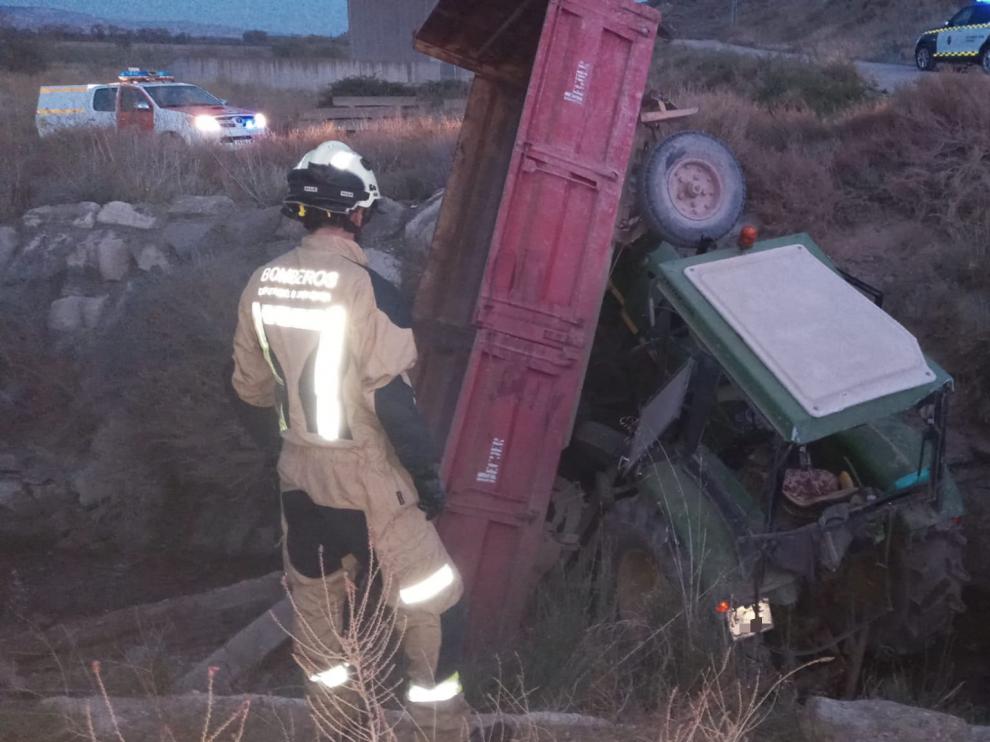 Los bomberos de la DPZ, rescatando al hombre que ha caído en una acequia con su tractor.