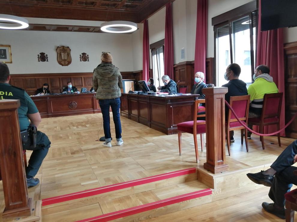 La acusada, de pie, en el momento de prestar declaración. A la derecha de la imagen, sentados, los otros dos procesados.
