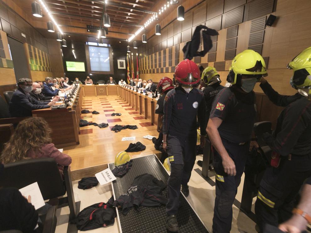 Los bomberos abandonan el salón de plenos tras lanzar al suelo los cascos, camisetas y carteles.