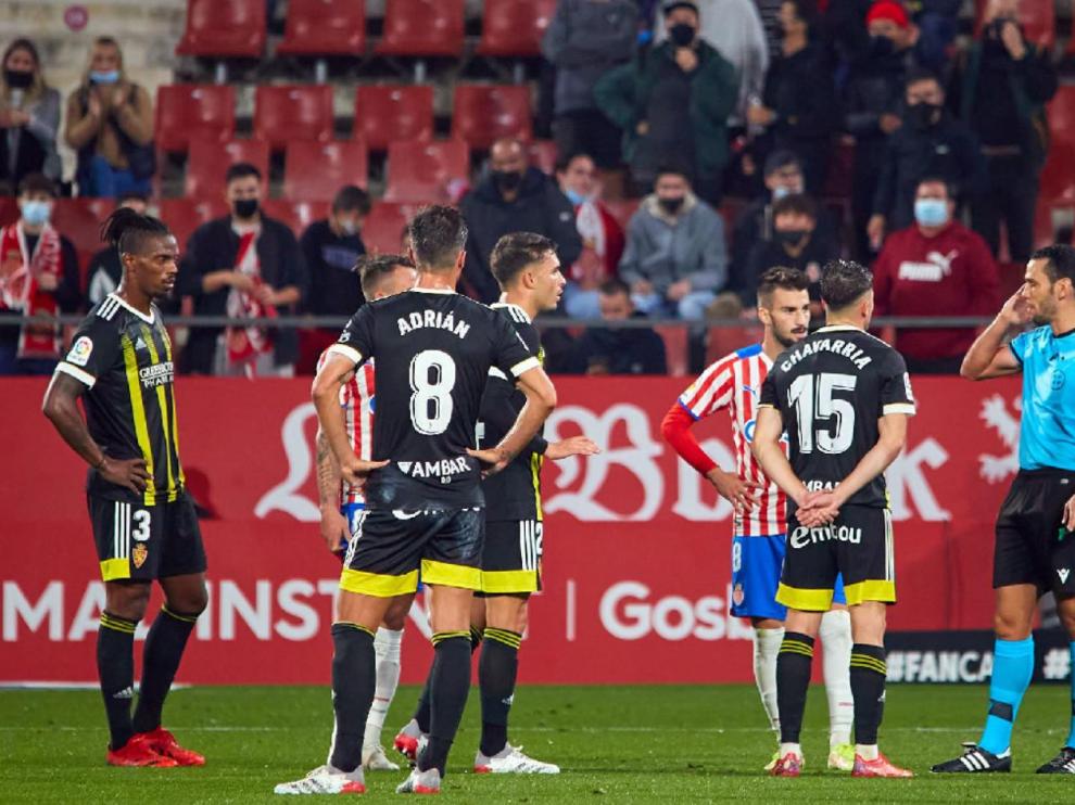 Los jugadores del Real Zaragoza aguardan la anulación del VAR de uno de los dos goles que marcó irregularmente el Girona y no subieron al marcador.