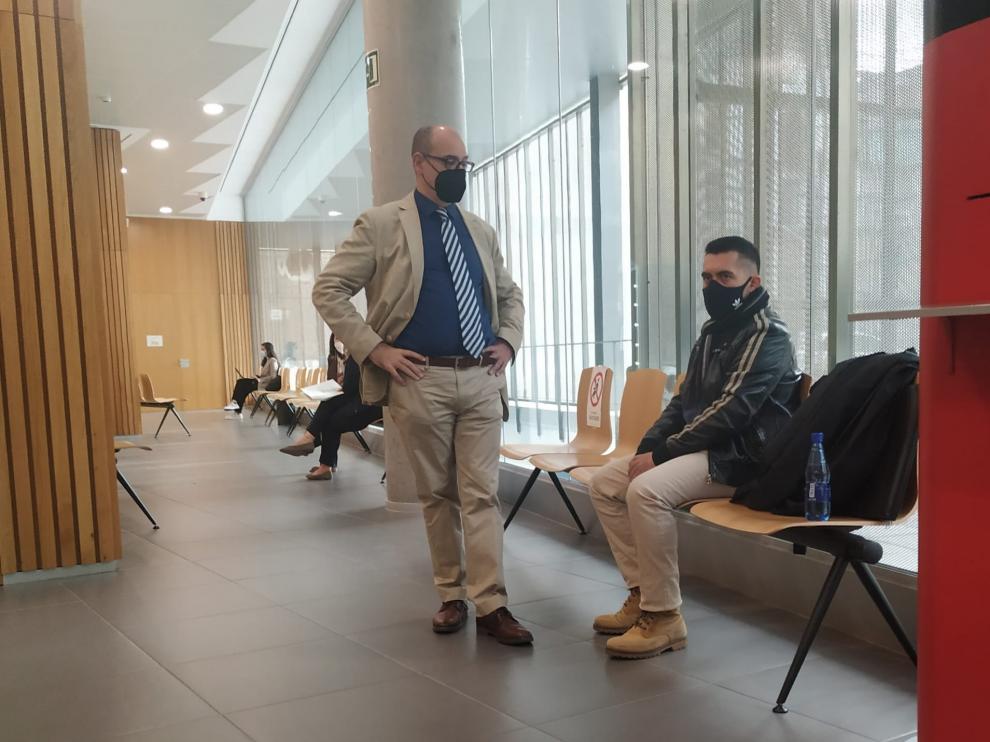 El condenado, sentado, junto a su abogado, en los pasillos de la Audiencia de Zaragoza.