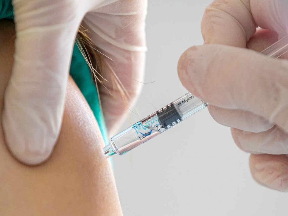 Una enfermera administra una dosis de vacuna de la gripe a un sanitario en el hospital Miguel Servet de Zaragoza.