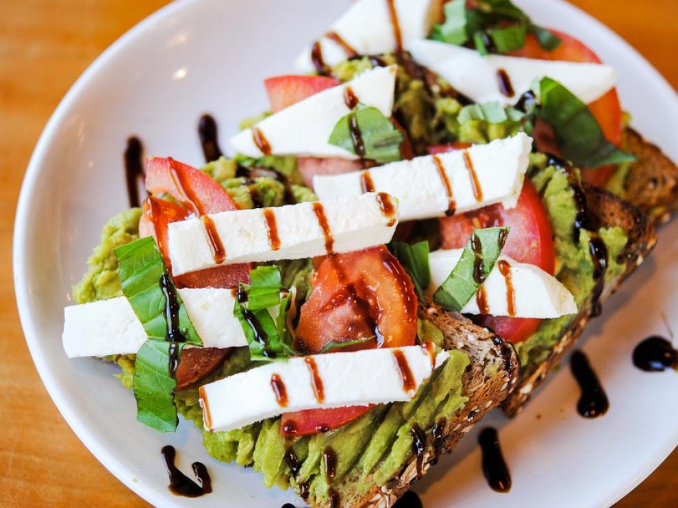 Una tostada de aguacate, queso fresco y atún.
