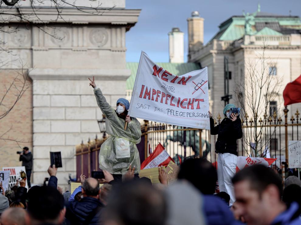 Demonstrators hold flags and placards as they gather to protest against the coronavirus disease (COVID-19) measures in Vienna, Austria, November 20, 2021. The placard reads: "For the truth, no to mandatory vaccination, protect our rights." REUTERS/Leonhard Foeger HEALTH-CORONAVIRUS/AUSTRIA-PROTEST