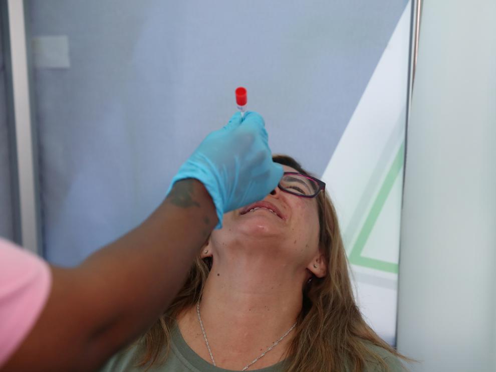 Healthcare worker collects a swab from Bronwen Cook for a PCR test against COVID-19 before traveling to London, at O.R. Tambo International Airport in Johannesburg