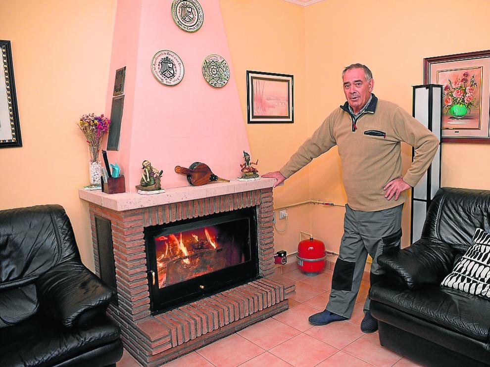Ramón Navarro, junto a la chimenea de leña que ha instalado en su casa de Villaspesa.