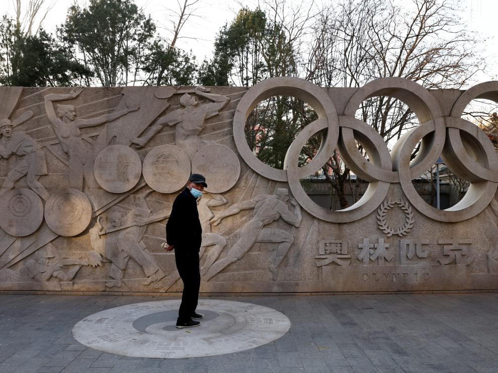 Un hombre junto a un monumento en Pekín que recuerda la celebración en breve de los Juegos Olímpicos.