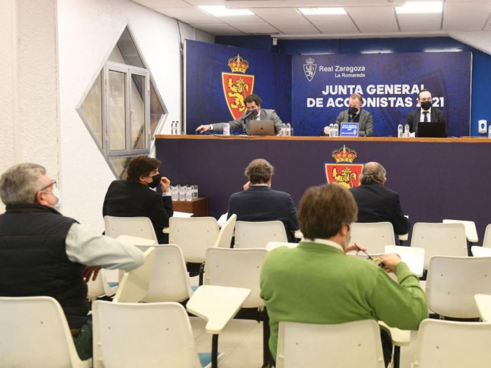Un pasaje de la Junta General de Accionistas del Real Zaragoza, este martes 21 de diciembre de 2021. Christian Lapetra, el presidente de la entidad, en el centro del estrado.