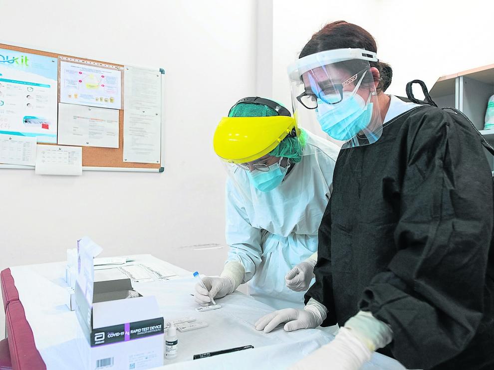 Dos enfermeras comprueban el resultado de un test de antígenos en el centro de Valdespartera.