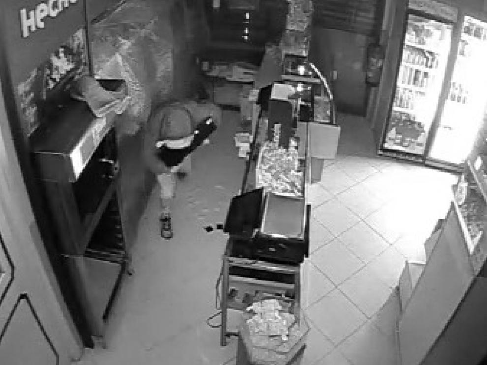 Uno de los detenidos por cometer robos en tiendas de frutos secos de Zaragoza, en plena acción en una imagen grabada por videocámara.