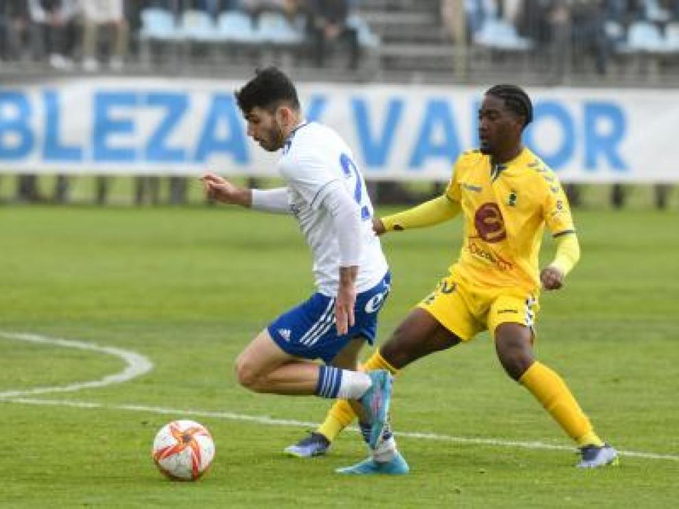 El canterano Miguel Puche avanza con el balón ante un futbolista del Robres.